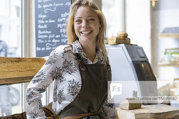 Lächelnde junge Frau in einem Lebensmittelladen stehend