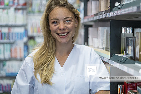 Porträt einer lächelnden jungen Frau in einer Apotheke