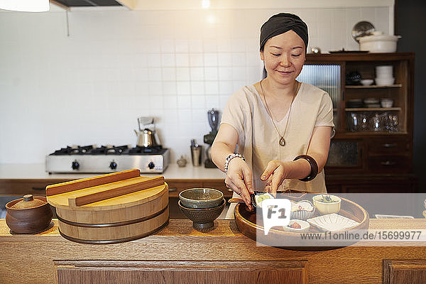 Japanerin  die in einem vegetarischen Café Essen zubereitet.