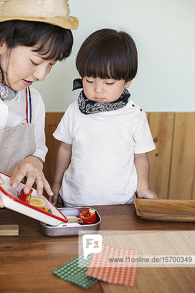 Japanese woman and boy standing in a farm shop  preparing food.