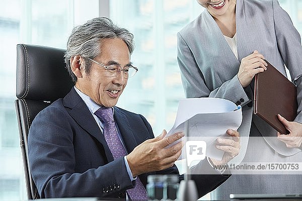 Älterer japanischer Geschäftsmann mit seiner Assistentin