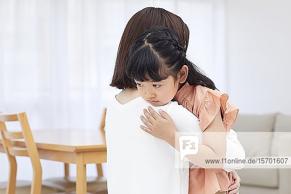 Japanische Mutter  die ihre Tochter umarmt