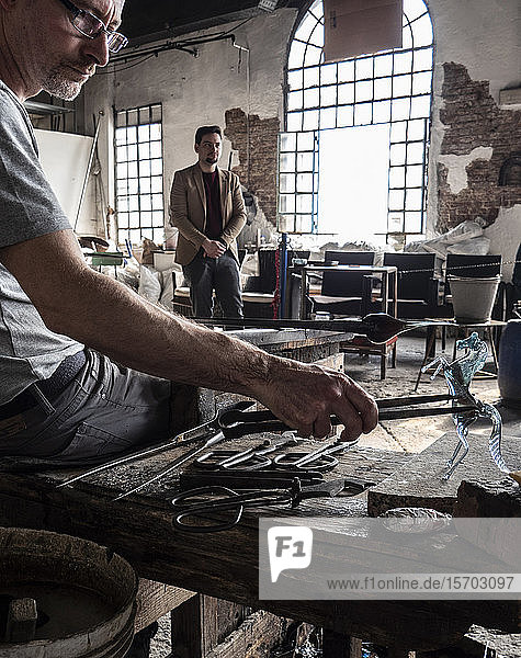 Italien  Venetien  Venedig  Insel Murano  Glasbläserkunst aus Murano  ein Handwerker bei der Glasbearbeitung in einer traditionellen Glashütte