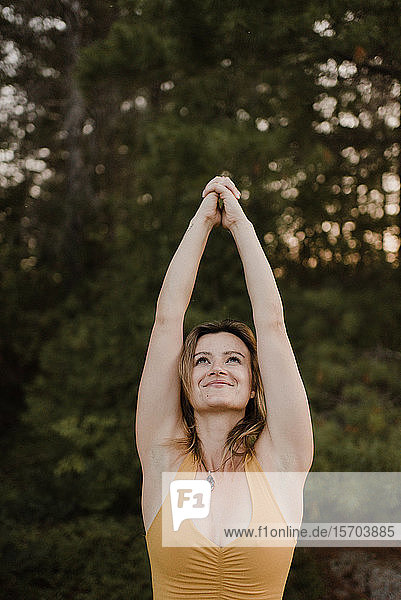 Frau praktiziert Yoga im Wald