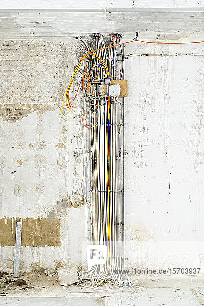 Bündel von Kabeln entlang der Wand auf der Baustelle
