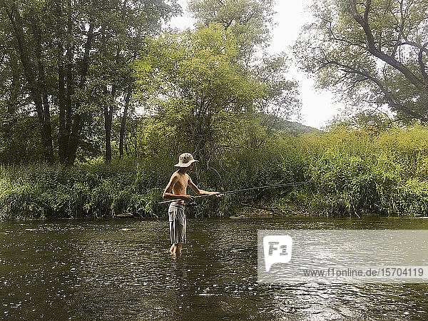 Junge beim Angeln in ländlichem Fluss