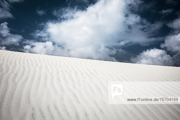 Muster über Sanddüne unter Wolken am Himmel
