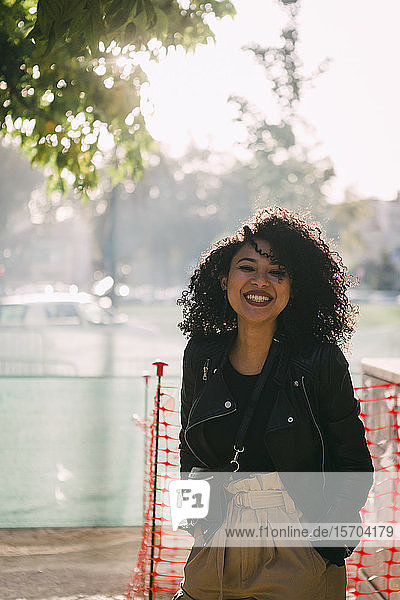 Porträt glückliche  sorglose junge Frau in sonnigem Park