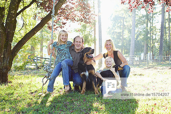 Portrait happy family with dogs in sunny autumn park