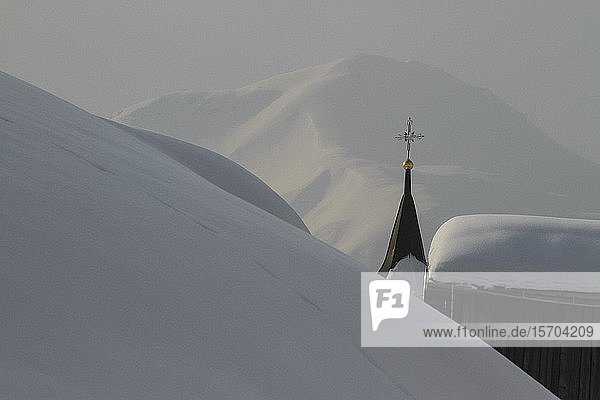 Kirchturm inmitten verschneiter Berge  Tujetsch  Kanton Graubünden  Schweiz