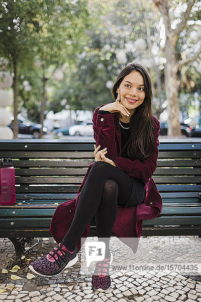 Portrait smiling  stylish woman on park bench