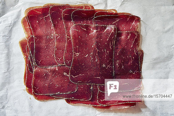 Ansicht von oben aufgeschnittenes  luftgetrocknetes Buendnerfleisch auf Fleischerpapier