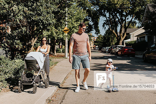 Vierköpfige Familie geht in der Nachbarschaft spazieren