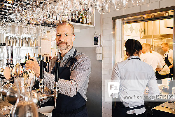 Männlicher und weiblicher Besitzer im Restaurant stehend