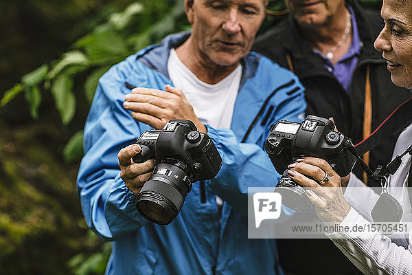 Älterer Mann zeigt einer Ausbilderin während eines Fotokurses die Kamera