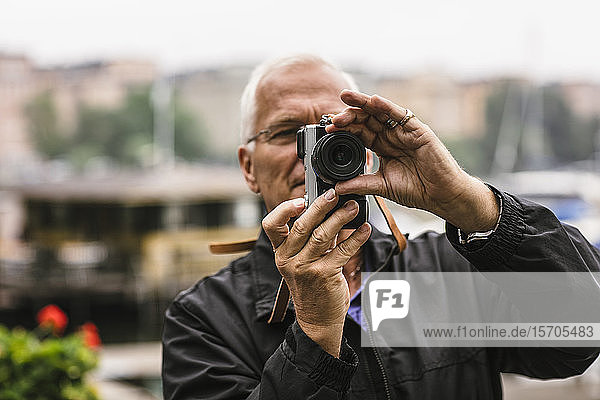 Älterer Mann benutzt Kamera während Fotografiekurs
