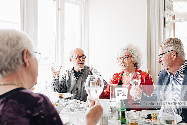 Ältere Freunde beim Weinglas-Toast im Restaurant