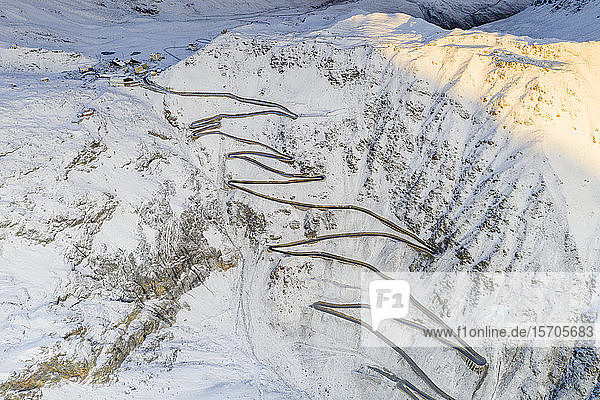 Enge Kurven der Stilfserjochstraße auf steilem  verschneitem Bergrücken  Luftaufnahme mit Drohne  Provinz Bozen  Südtirol  Italien  Europa