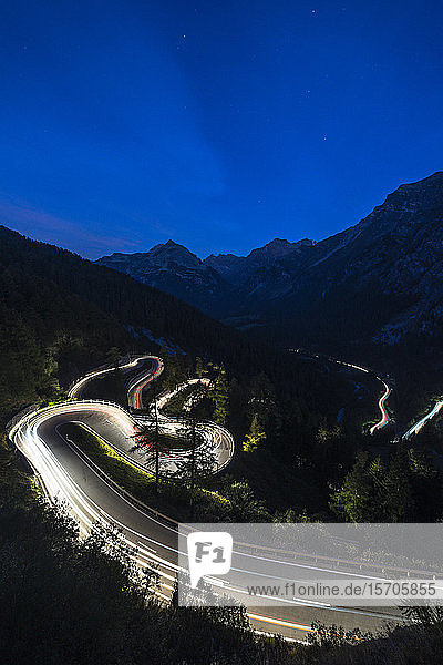 Light trails on the hairpin curves of Maloja Pass mountain road at night Engadine Canton of Graubunden Switzerland Europe