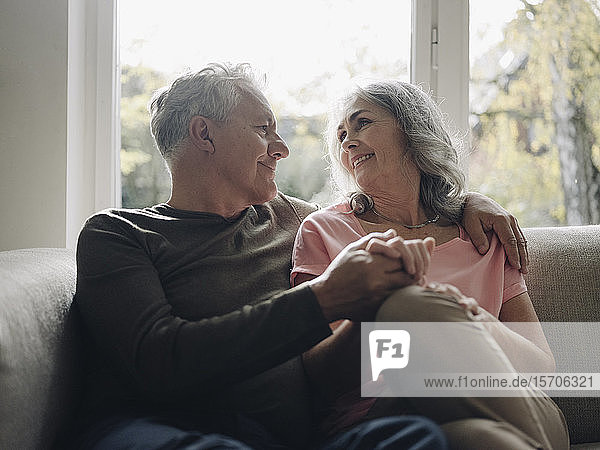 Affectionate senior couple relaxing on couch at home
