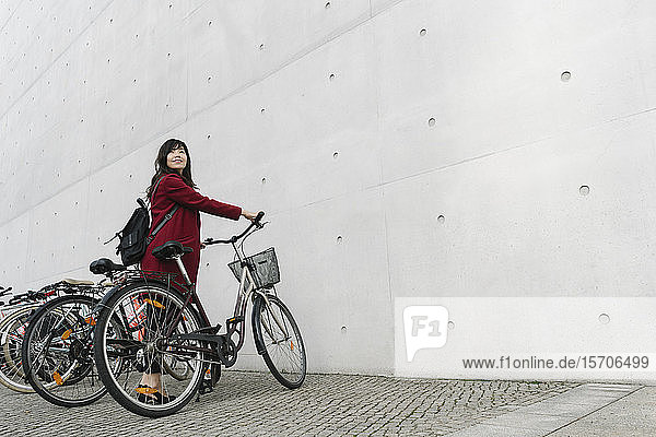 Geschäftsfrau mit Fahrrad im Hintergrund des modernen Gebäudes