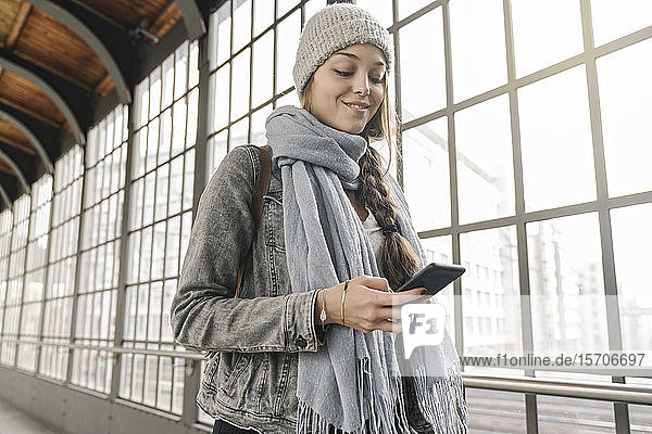 Junge Frau mit Smartphone auf dem Bahnsteig  Berlin  Deutschland