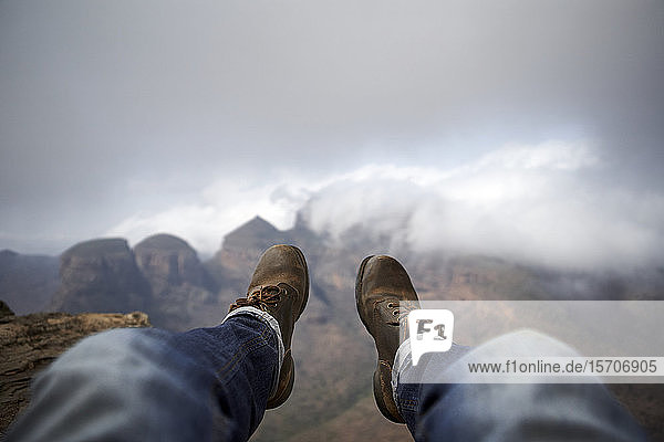 Mann mit einem Paar alter Stiefel auf dem Gipfel eines Hügels mit Blick auf den nebligen Blyde River Canyon  Südafrika