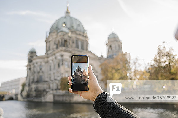 Nahaufnahme eines Mannes  der ein Smartphone-Foto vom Berliner Dom macht  Berlin  Deutschland