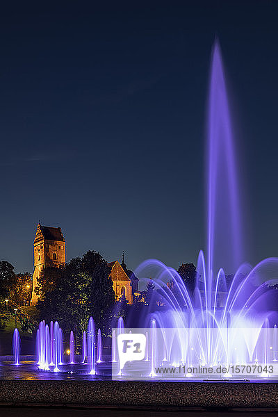 Polen Woiwodschaft Masowien Warschau Violetter Brunnen im Multimedia-Brunnenpark bei Nacht mit der Marienkirche im Hintergrund