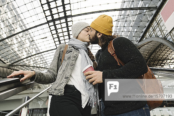 Junges Paar küsst sich auf einer Rolltreppe am Bahnhof  Berlin  Deutschland