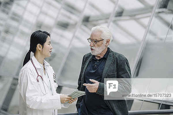 Ärztin im Gespräch mit älterem Mann