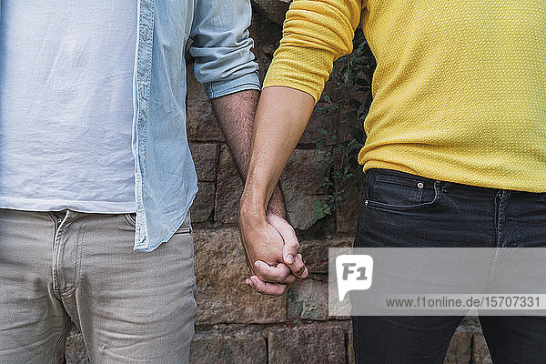 Crop view of gay couple hand in hand
