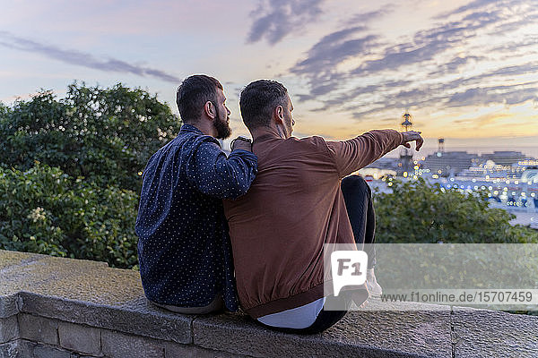 Gay couple on lookout above the city with view to the port  Barcelona  Spain