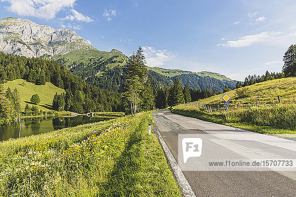 Österreich  Kärnten  Blick auf eine leere Straße im bewaldeten Tal der Karnischen Alpen im Sommer