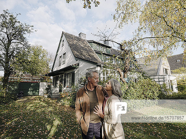 Senior couple in garden of their home in autumn