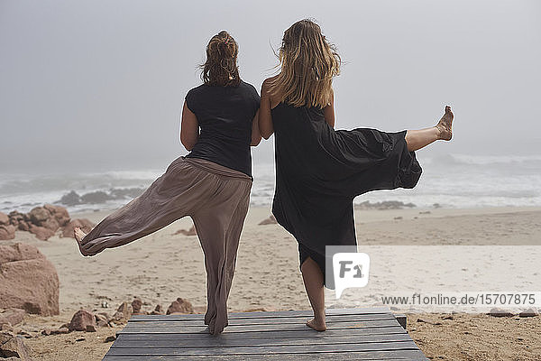 Rückansicht von zwei Frauen beim Yoga am Meer  Cape Cross  Namibia