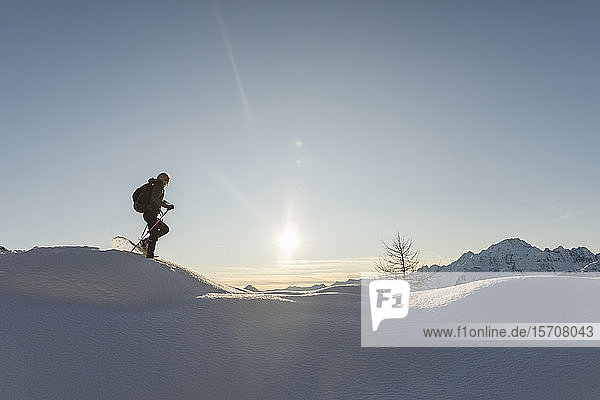 Frau wandert mit Schneeschuhen im Neuschnee in den Bergen Valmalenco Italien