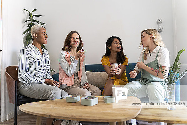 Vier Frauen sitzen auf der Couch und unterhalten sich