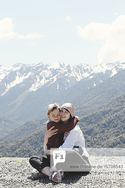 Mother hugging her son in the mountains  Sochi  Russia