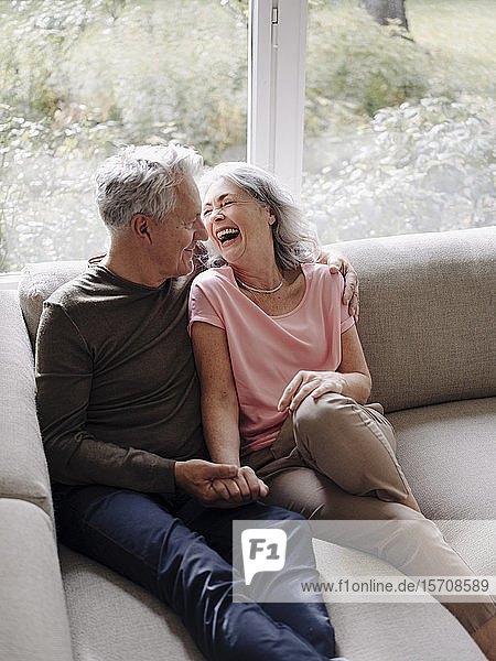 Glückliches älteres Ehepaar entspannt sich zu Hause auf der Couch