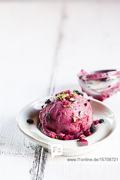 Teller veganer zuckerfreier schöner Sahne mit Himbeeren, Bananen, Pistazien und Schokolade