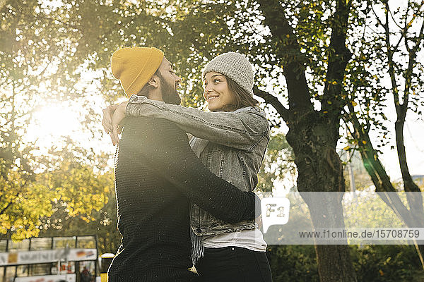 Junges Paar umarmt sich in einem Stadtpark  Berlin  Deutschland