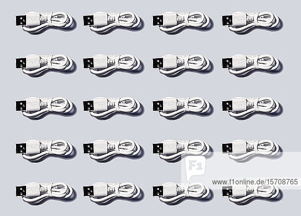 3D-Illustration  weiße USB-Kabel in einer Reihe auf grauem Hintergrund