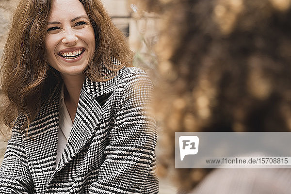 Two happy women meeting and talking outdoors in the city