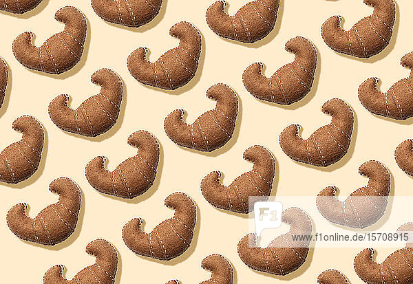 3D-Illustration  Plüsch-Fake-Croissantmuster auf cremefarbenem Hintergrund