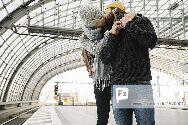 Junges Paar küsst sich auf dem Bahnsteig  Berlin  Deutschland