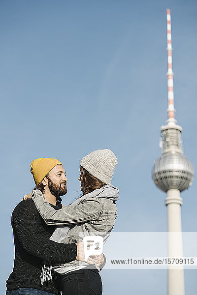 Junges Paar umarmt sich mit Fernsehturm im Hintergrund  Berlin  Deutschland