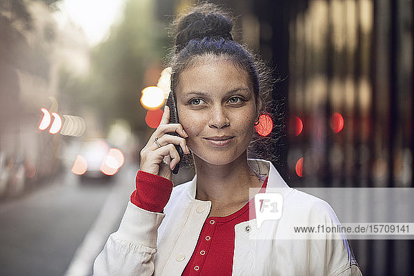 Portrait of young woman on the phone in the city