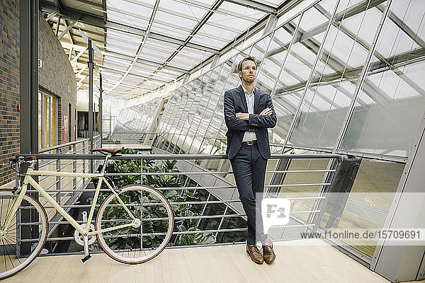 Geschäftsmann mit Fahrrad in modernem Bürogebäude