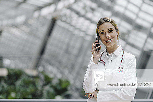 Porträt einer lächelnden Ärztin am Telefon